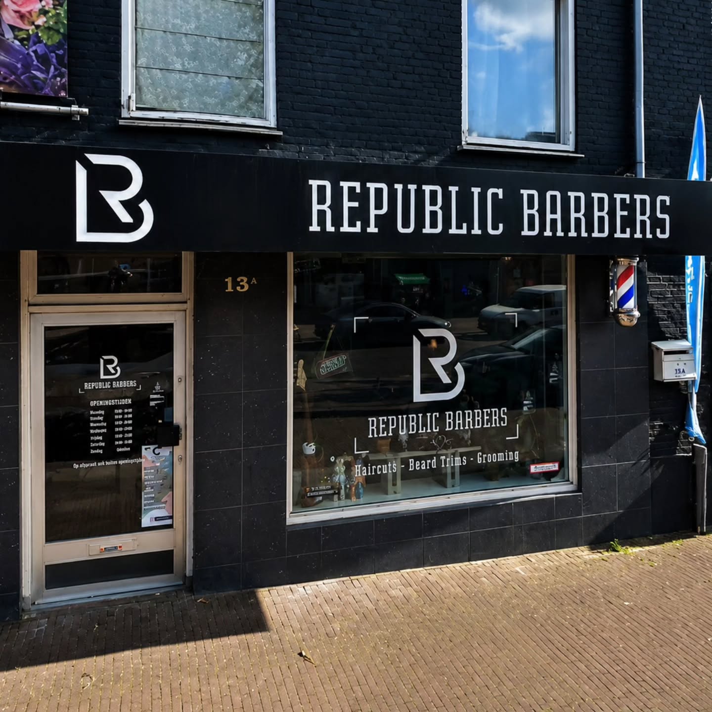 De gevel van Republic Barbers aan de Mierloseweg 13A in Helmond, met zwart pui, barberpole en het RB-monogram op het raam